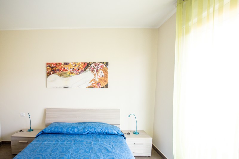 Camera matrimoniale con due comodini beige chiaro con le abat jour ed un quadro Appartamento Pineto Vacanza Residence Claudia int. V