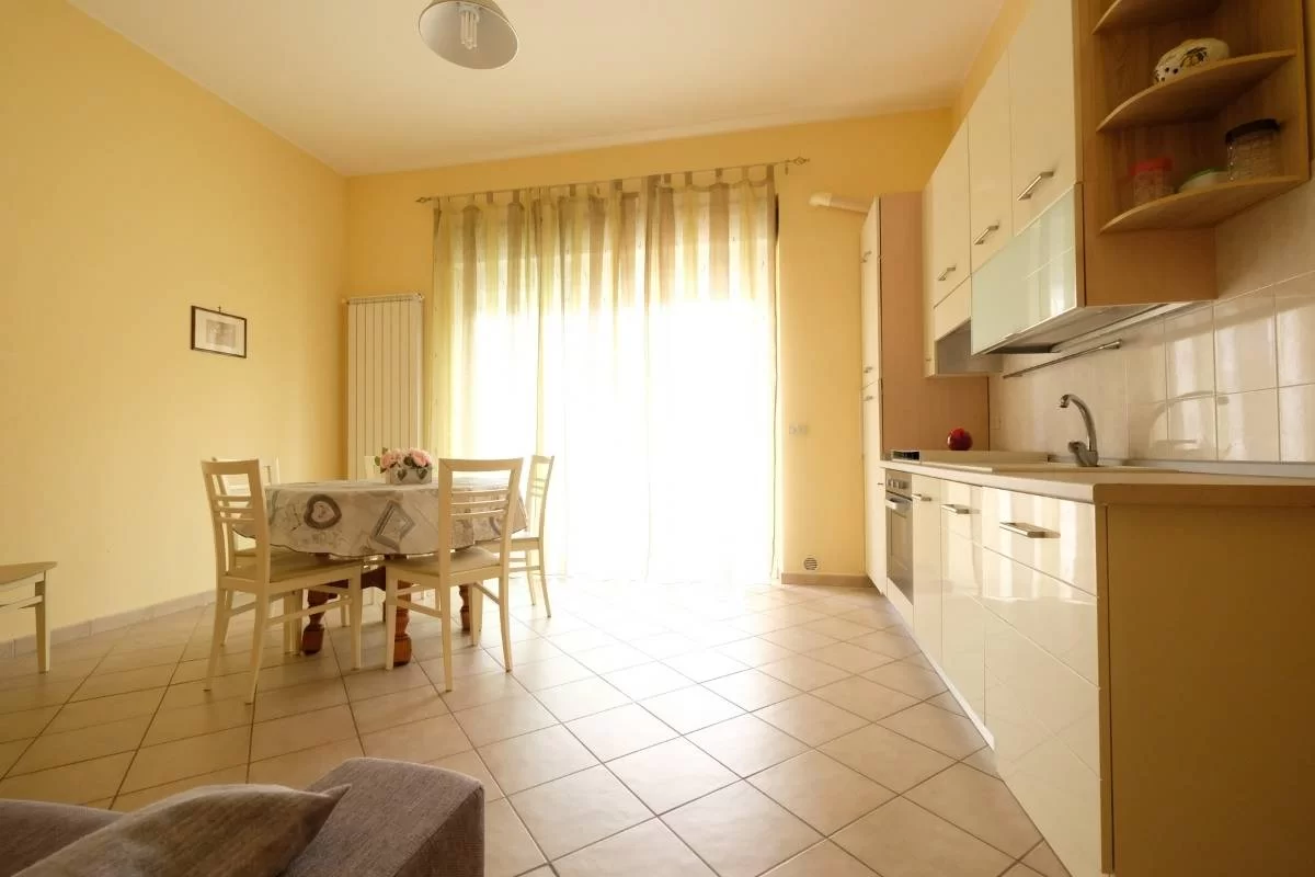 Cucina bianco panna con tavolo e sedie e finestra a porta con finestra Appartamento Pineto Vacanza Armonia