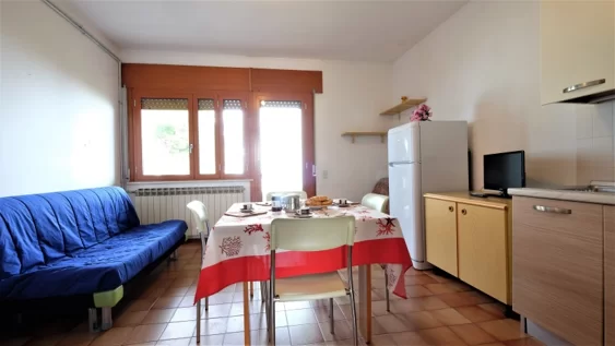 Cucina con sofà blu e tavolo con sedie Appartamento Pineto Vacanza Caterina A3