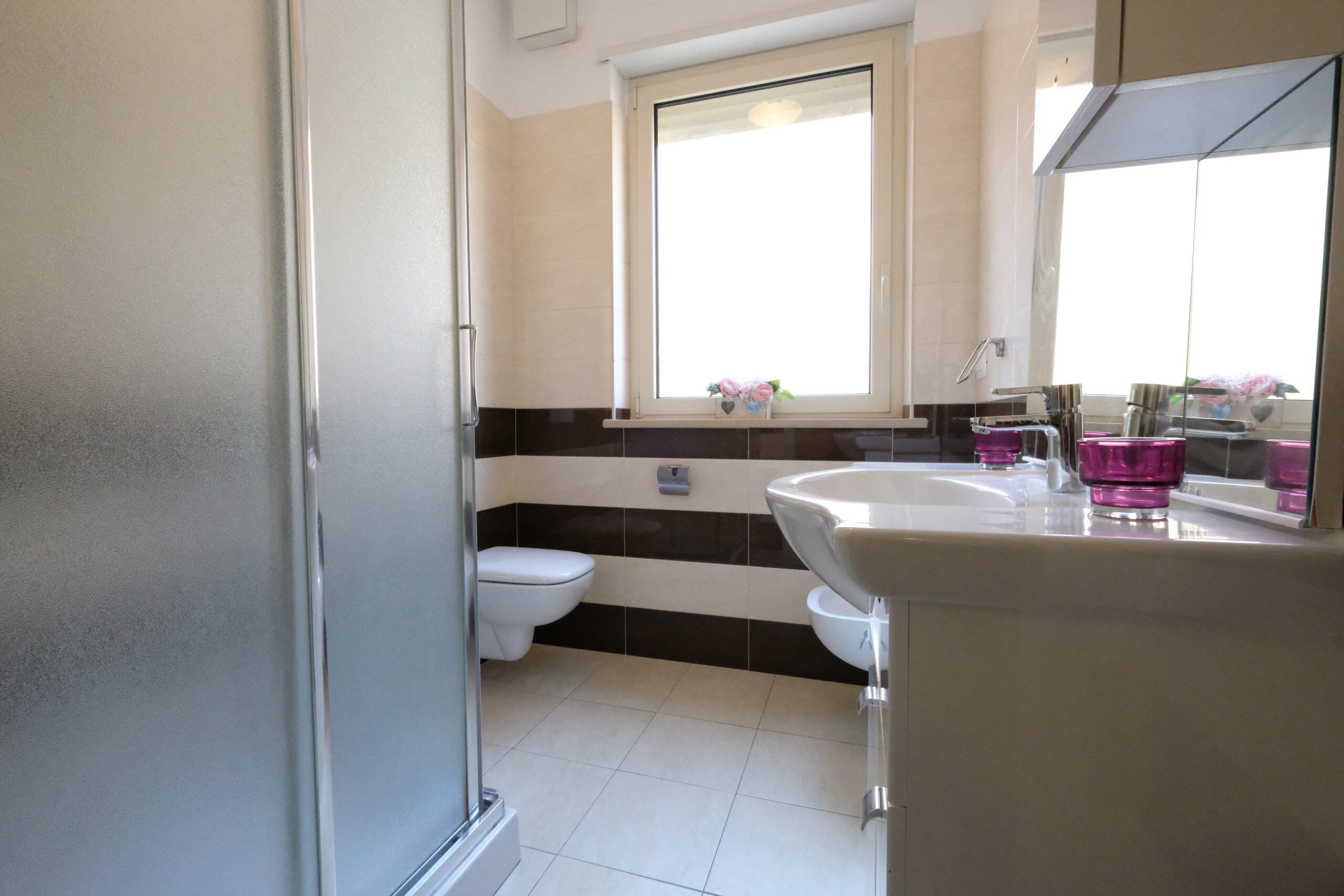 Bagno con lavandino, gabinetto, doccia e finestra di piccole dimensioni Appartamento Pineto Vacanza Residence Claudia int. F