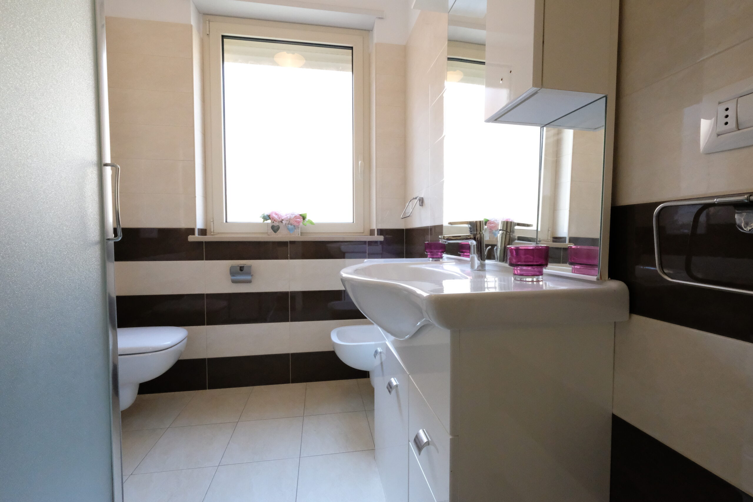 Bagno con credenza a specchio e lavandino ed una finestra piccola Appartamento Pineto Vacanza Residence Claudia int. F