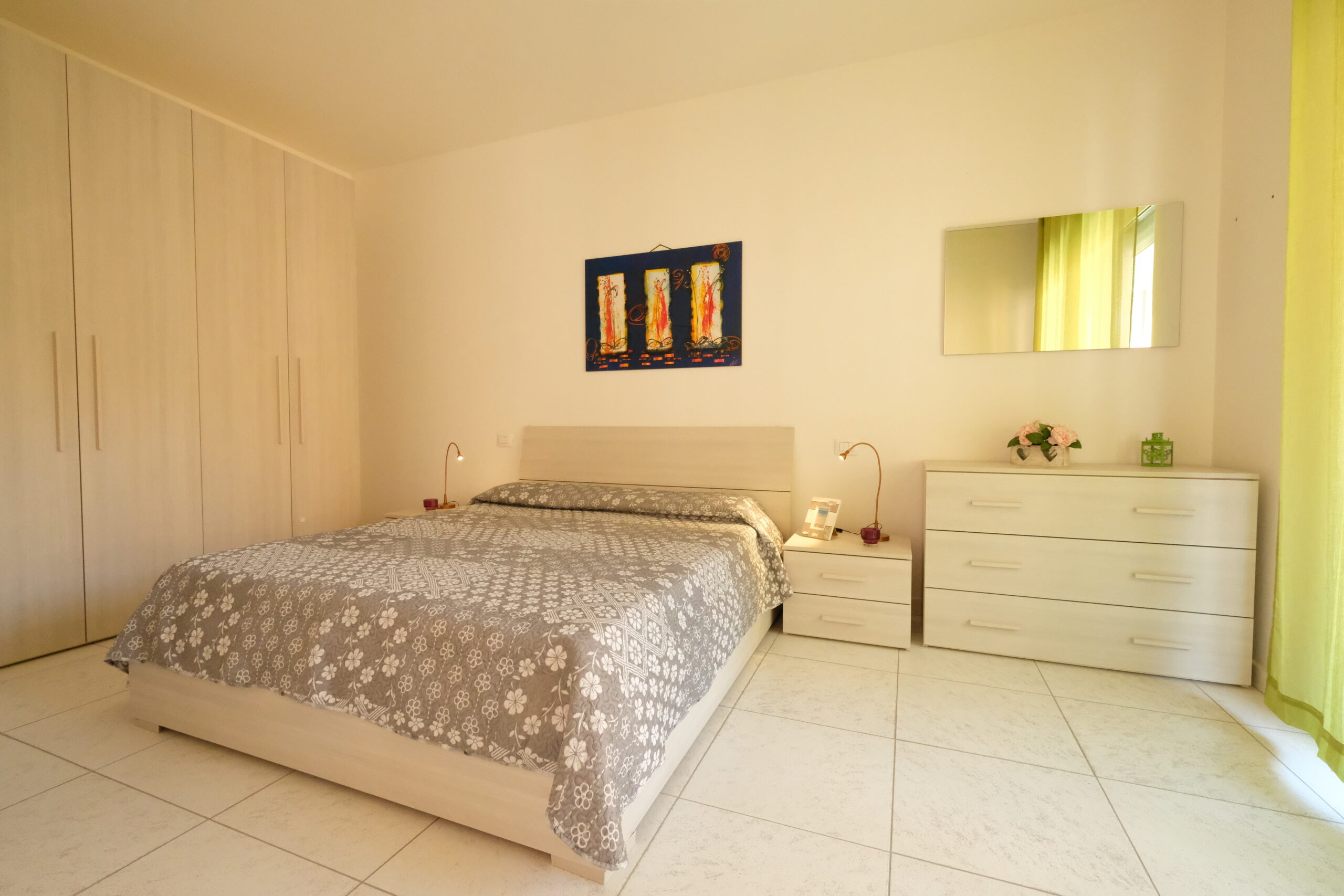 Camera con letto matrimoniale con credenza beige e specchio Appartamento Pineto Vacanza Residence Claudia int. I