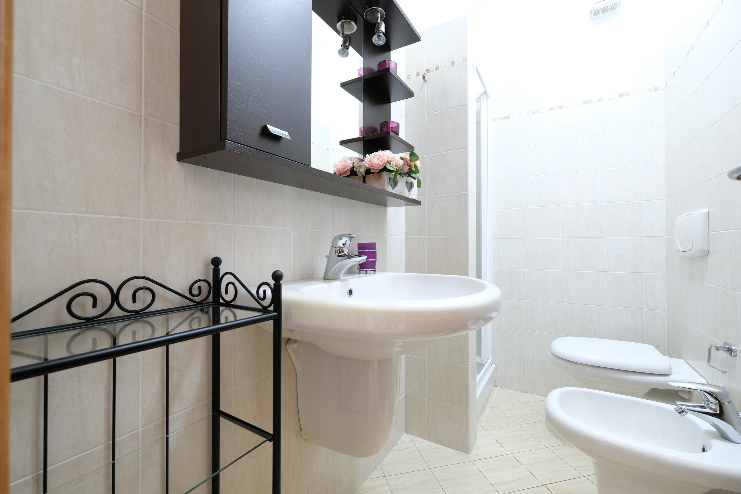Bagno con gabinetto, bidet, lavandino con armadietto e specchio Appartamento Pineto Vacanza Poseidon 1