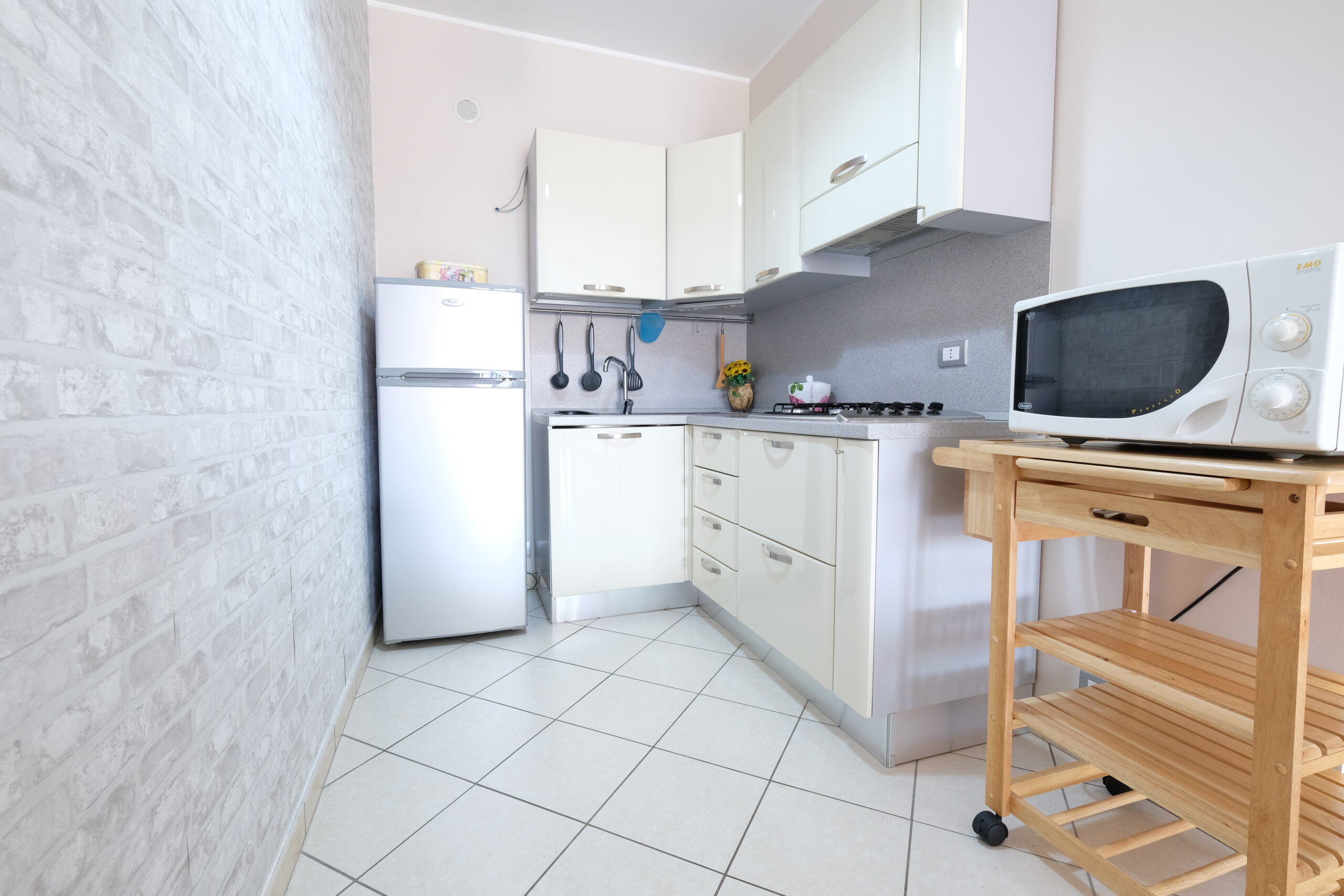 Cucina piccola bianca con frigorifero e microonde Appartamento Pineto Vacanza Poseidon 1