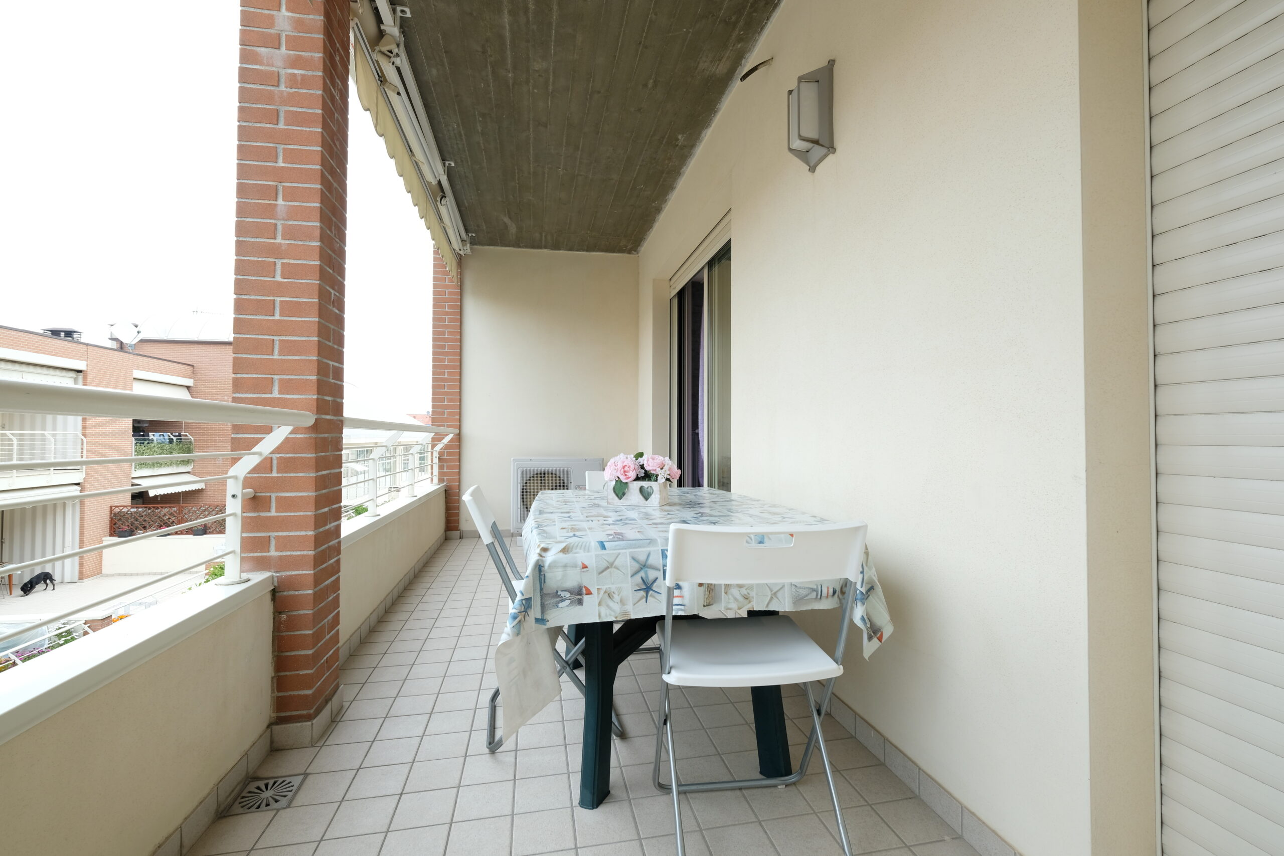 Balcone con tavolo da giardino e sedie bianche Appartamento Pineto Vacanza Poseidon 1