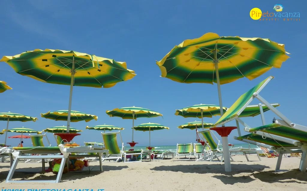 Ombrelloni giallo-verdi sulla spiaggia Appartamento Pineto Vacanza Gemma 2