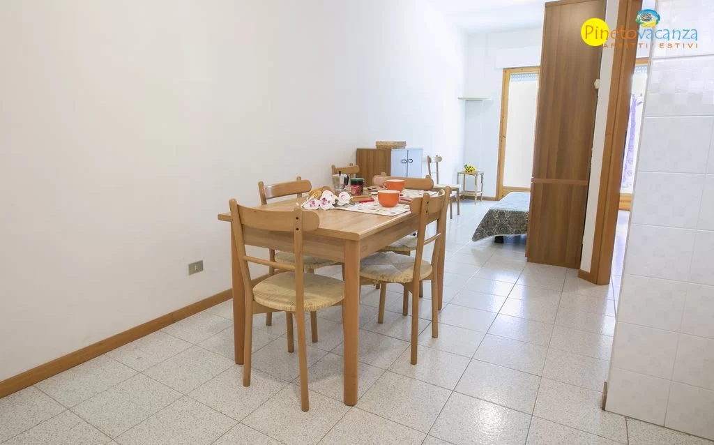 Cucina con tavolo e sedie in legno Appartamento Pineto Vacanza Gemma