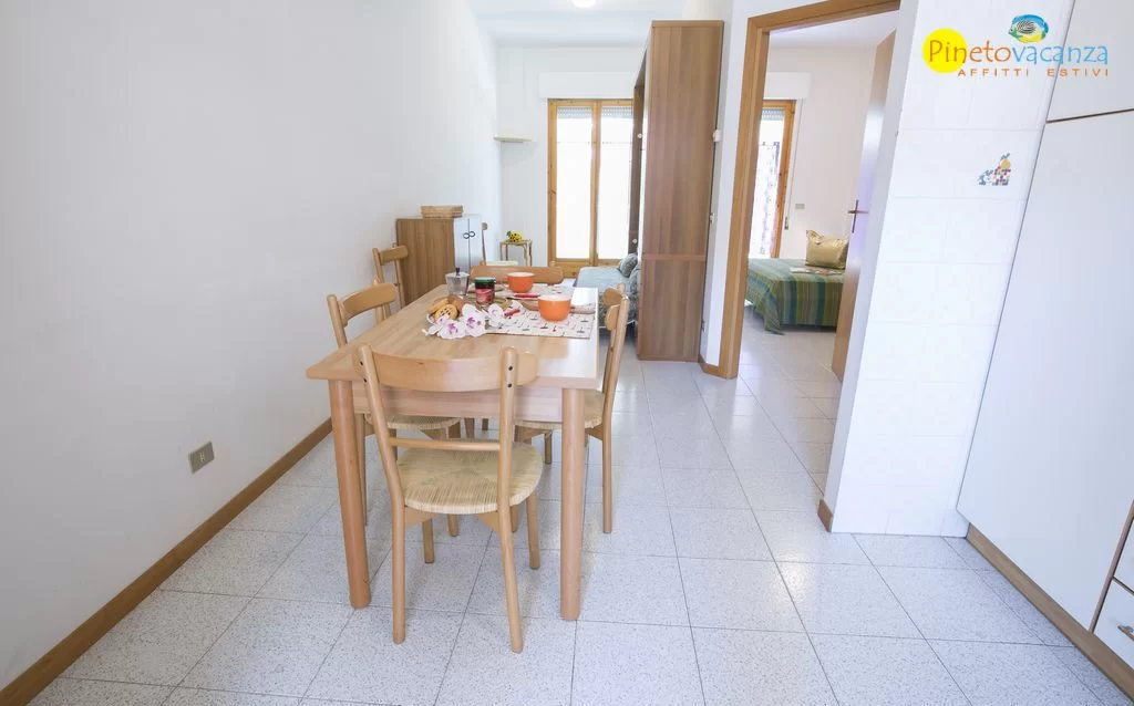 Cucina con tavolo e sedie in legno Appartamento Pineto Vacanza Gemma