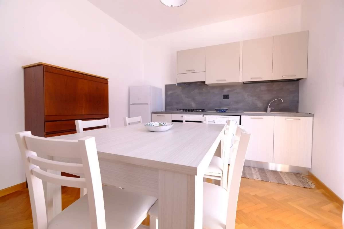 Cucina bianca con tavolo e sedie bianche Appartamento Pineto Vacanza Lady