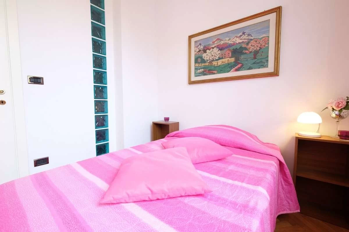Camera singola con letto e coperte fucsia Appartamento Pineto Vacanza Lady