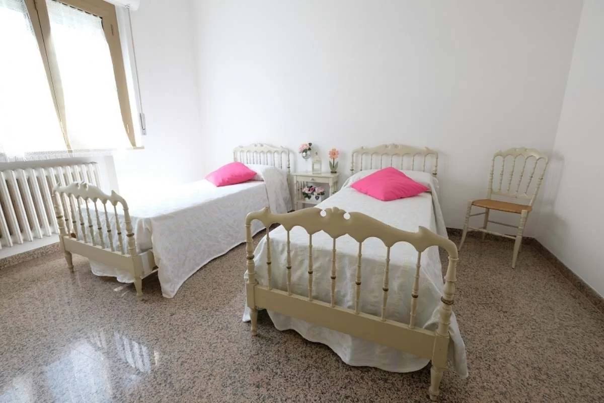 Camera doppia con due letti singoli con comodino e sedia Appartamento Pineto Vacanza Malibù