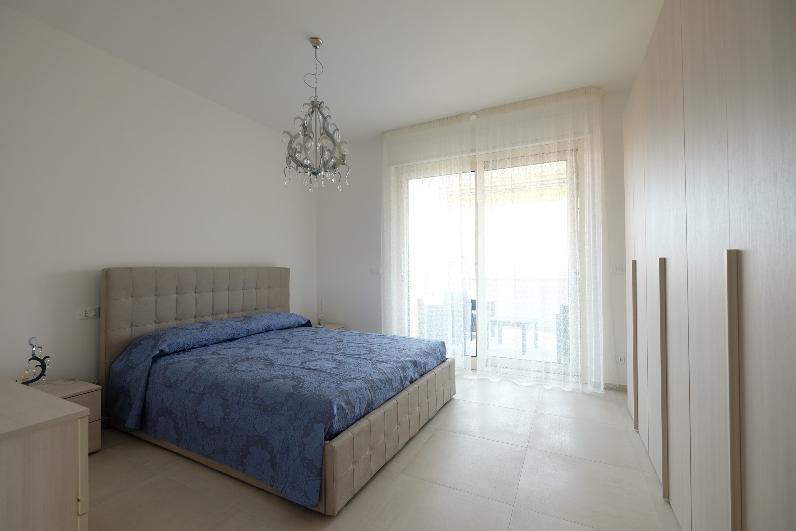 Camera matrimoniale con finestra a porta con tende bianche Appartamento Pineto Vacanza Residence Claudia Luxury