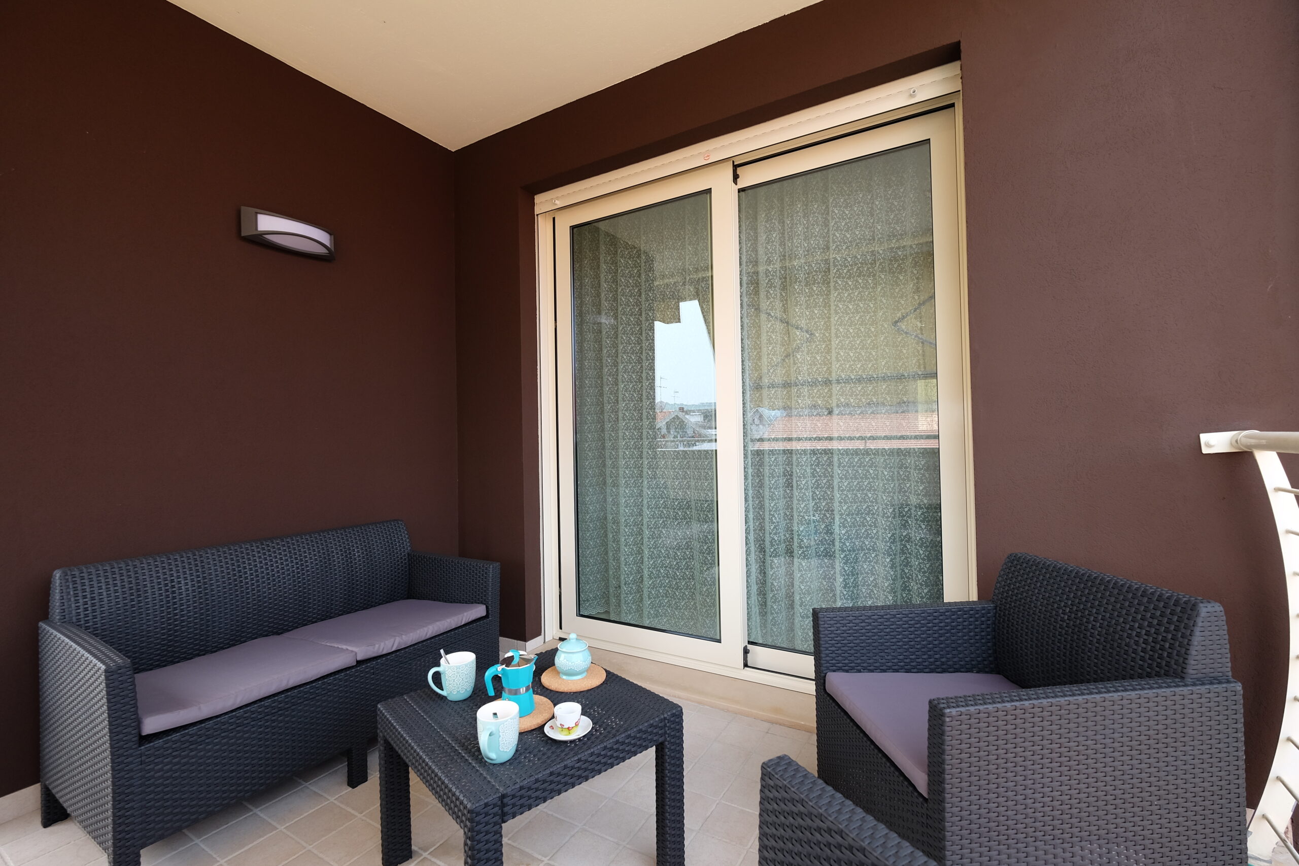 Balcone arredato con divanetti da giardino e tavolino marrone scuro Appartamento Pineto Vacanza Residence Claudia Luxury
