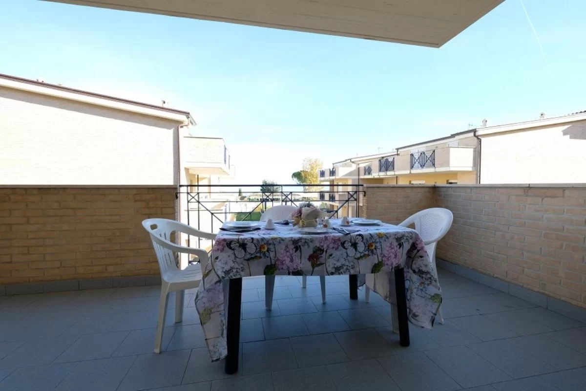 Balcone con tavolino da giardino e sedie bianche Appartamento Pineto Vacanza Green Bay A12