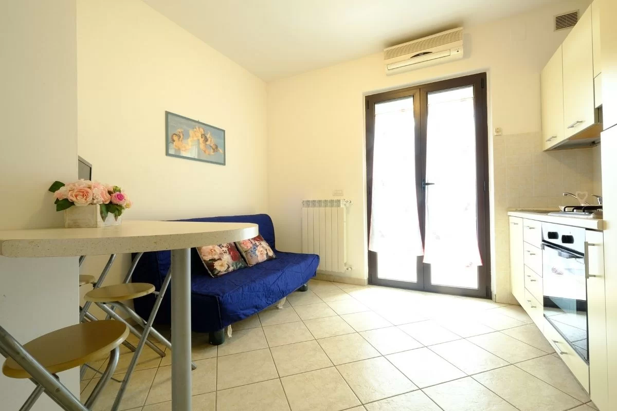 Sala con divano blu e finestra a porta Appartamento Pineto Vacanza Micaene C3