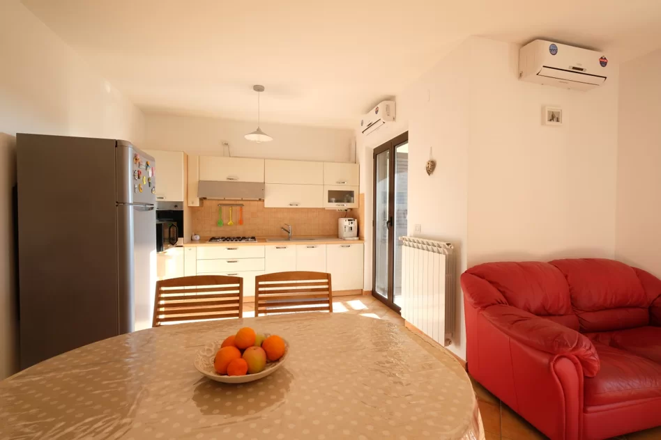 Cucina e sale con divano e tavolo con sedie Appartamento Pineto Vacanza Micaene Duplex