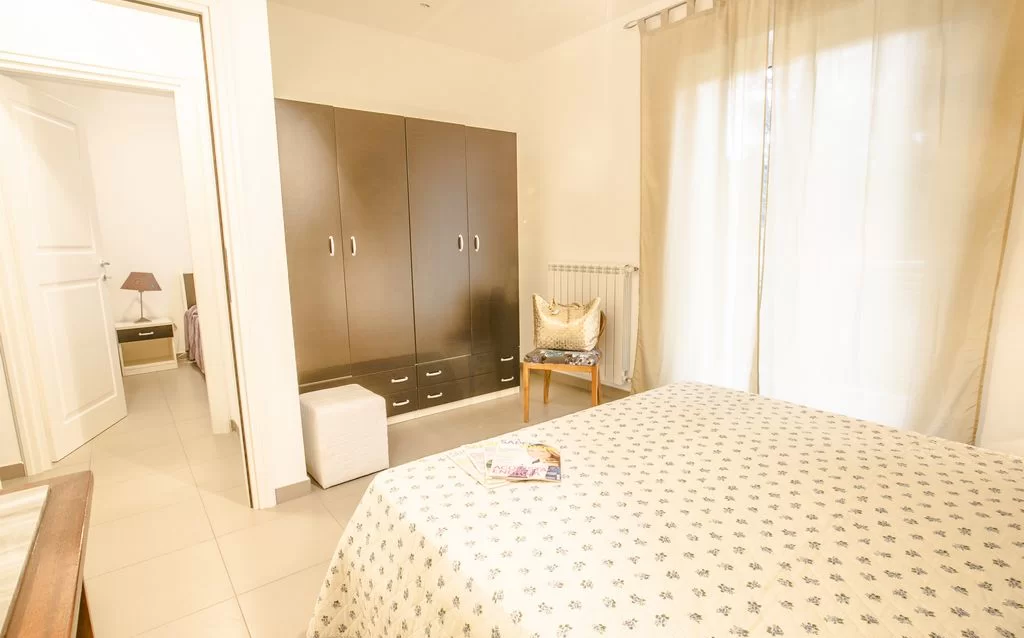 Camera da letto con armadio marrone e finestra a porta con tenda Appartamento Pineto Vacanza Myconos Deluxe D3