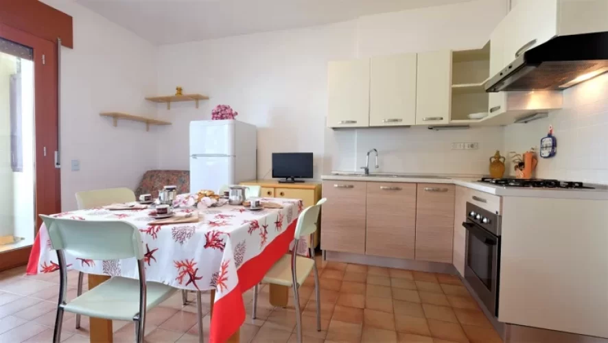 Cucina bianca con tavolo e sedie bianche Appartamento Pineto Vacanza Caterina A3