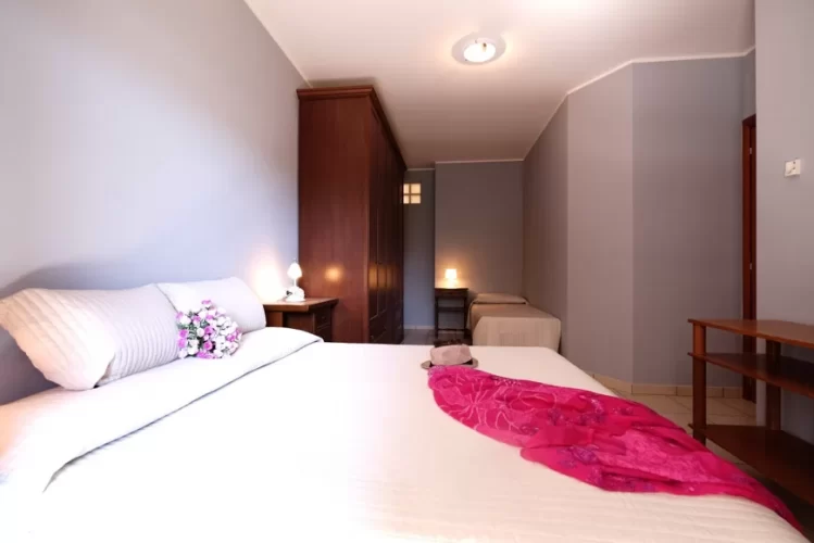 Camera tripla con letto matrimoniale e letto singolo con armadio marrone Appartamento Pineto Vacanza Ficus Plus