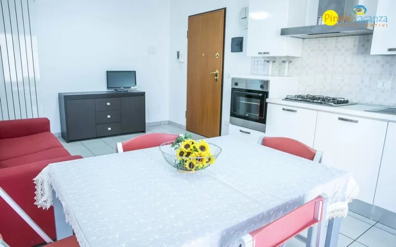 Cucina bianca con tavolo e sedie Appartamento Pineto Vacanza Ficus