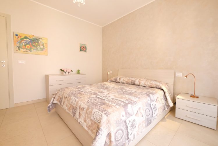 Camera matrimoniale con comò e comodino beige Appartamento Pineto Vacanza Residence Claudia int. L