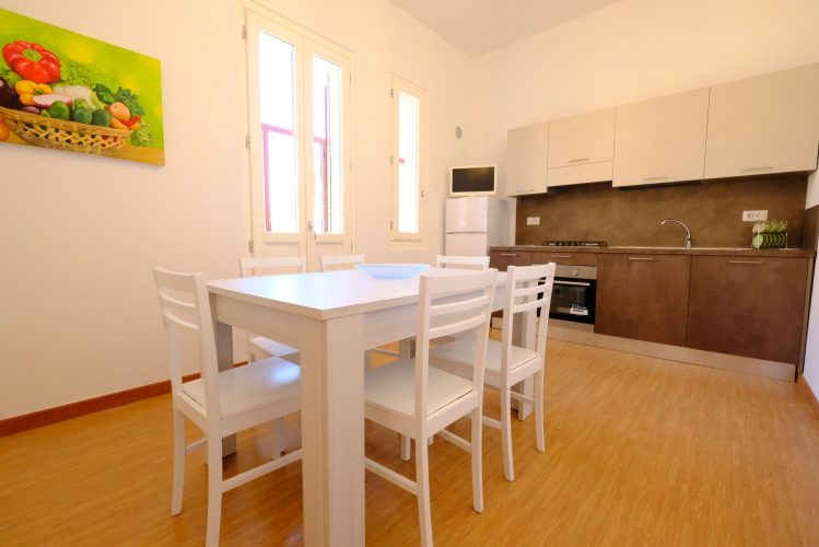 Cucina marrone con tavolo e sedie color bianco Appartamento Pineto Vacanza Lady 2