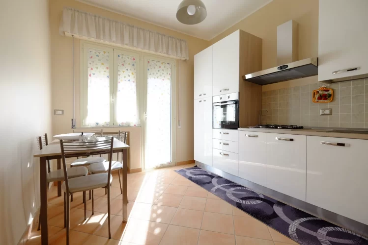 Cucina bianca con tavolo e sedie Appartamento Pineto Vacanza Ginevra
