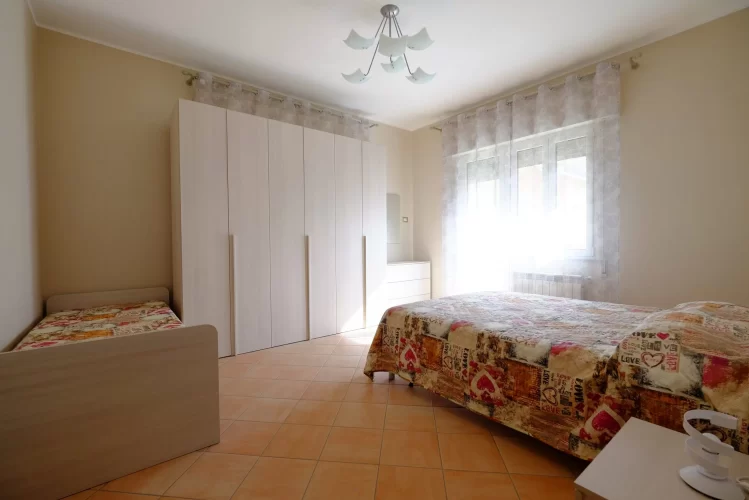 Camera tripla con letto matrimoniale e singolo ed armadio beige Appartamento Pineto Vacanza Ginevra