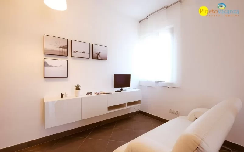 Sala con divano bianco e televisione Appartamento Pineto Vacanza Mango 2