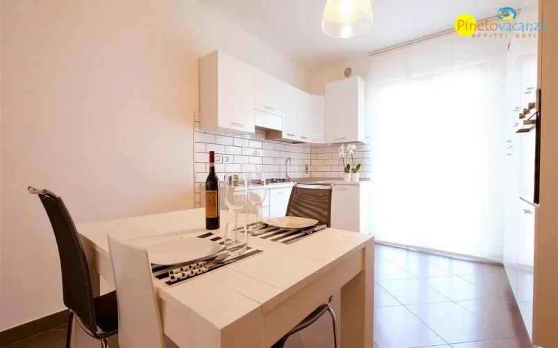Cucina bianca con tavolo bianco e sedie Appartamento Pineto Vacanza Mango 2
