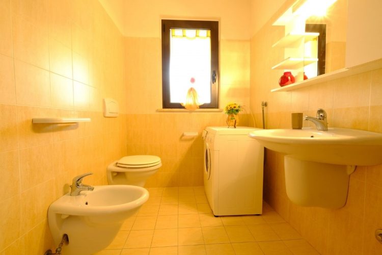 Bagno con lavandino e credenza specchio, lavatrice, bidet e gabinetto Appartamento Pineto Vacanza Micaene D3
