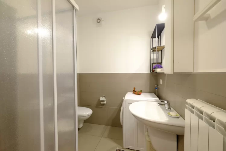 Bagno con lavandino, lavatrice, doccia e gabinetto Appartamento Pineto Vacanza Myconos C2