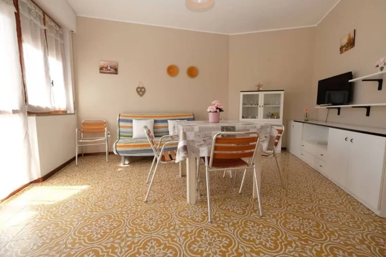 Sala con tavolo e sedie, divano colorato e televisione Appartamento Pineto Vacanza Pinetina D2