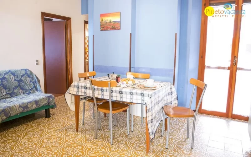 Sala con tavolo e sedie, divano e finestra Appartamento Pineto Vacanza Pinetina D3